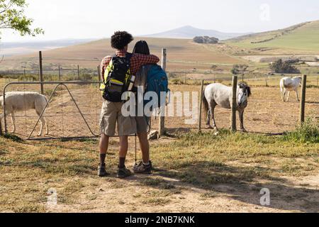 Glückliches afroamerikanisches Paar, das sich an einem sonnigen Tag auf dem Land umarmt. Land-, Natur- und Lifestyle-Konzept. Stockfoto
