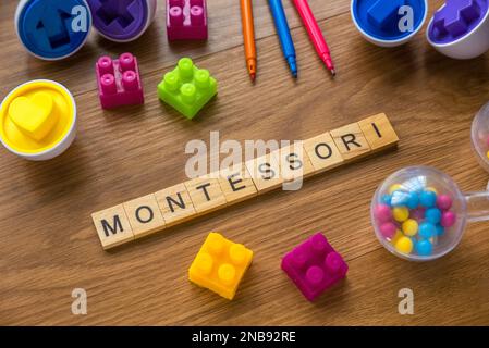 Montessori über ein hölzernes Alphabet-Konzept mit Spielzeug auf Holzhintergrund. Stockfoto