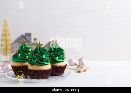 Weihnachtlich baumförmige Cupcakes auf weißem Tisch. Platz für Text Stockfoto