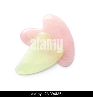 Gua-Sha-Werkzeuge aus Jade und Rosenquarz auf weißem Hintergrund, Draufsicht Stockfoto