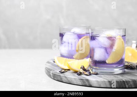 Organischer blauer Anker mit Zitrone auf dem hellen Tisch, Platz für Text. Kräutertee Stockfoto