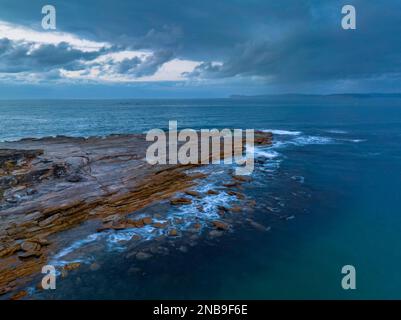 Sonnenaufgang mit Regenwolken am Putty Beach an der Central Coast, NSW, Australien. Stockfoto