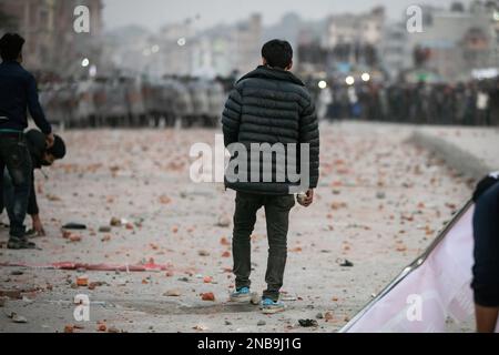 Kathmandu, Nepal. 13. Februar 2023. Demonstranten werfen Ziegel und Steine auf die Polizei während einer Demonstration. Die Transportunternehmen führten eine Demonstration gegen die „trügerischen“ Regeln der Verkehrspolizei durch und verkündeten Kathmandu Metropolitan City, dass öffentliche Fahrzeuge auf langen und mittleren Strecken nicht auf anderen freien Plätzen als im New Bus Park in Gongabu parken dürfen. Kredit: SOPA Images Limited/Alamy Live News Stockfoto