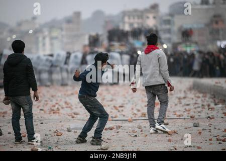 Kathmandu, Nepal. 13. Februar 2023. Demonstranten werfen Ziegel und Steine auf die Polizei während einer Demonstration. Die Transportunternehmen führten eine Demonstration gegen die „trügerischen“ Regeln der Verkehrspolizei durch und verkündeten Kathmandu Metropolitan City, dass öffentliche Fahrzeuge auf langen und mittleren Strecken nicht auf anderen freien Plätzen als im New Bus Park in Gongabu parken dürfen. Kredit: SOPA Images Limited/Alamy Live News Stockfoto