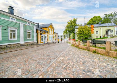 Farbenfrohe Holzgebäude säumen die Kopfsteinpflasterstraße am Eingang zur mittelalterlichen Altstadt von Porvoo. Stockfoto