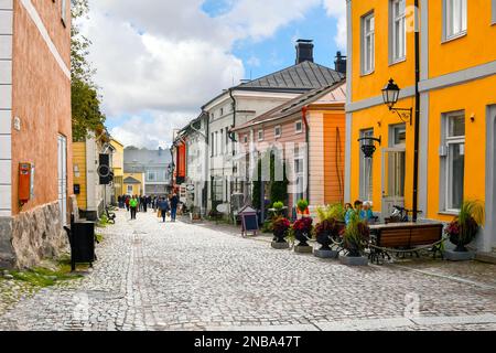 Farbenfrohe und malerische Geschäfte, Cafés und Holzgebäude säumen die Hauptkopfsteingepflasterstraße durch die mittelalterliche Altstadt von Porvoo, Finnland. Stockfoto