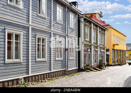 Farbenfrohe und malerische Geschäfte und Holzgebäude säumen die Hauptkopfsteingepflasterstraße durch die mittelalterliche Altstadt von Porvoo, Finnland Stockfoto