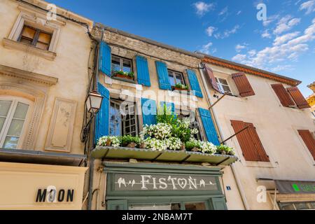 Ein mit malerischen Blumen gefülltes Fenster an einer Fassade für Boutiquen und Souvenirläden und Eingang in das historische französische Dorf Saint-Remy-de-Provence, Frankreich. Stockfoto