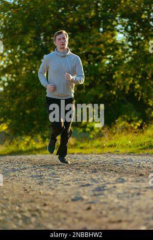 Jogging Mann Joggen in ländlicher Natur an schönen Sommertag. Sport Fitness Modell kaukasischen Ethnizität Training im Freien. Stockfoto