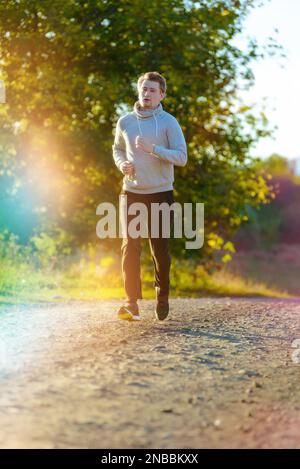 Jogging Mann Joggen in ländlicher Natur an schönen Sommertag. Sport Fitness Modell kaukasischen Ethnizität Training im Freien. Stockfoto