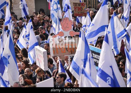 Jerusalem, Israel. 13. Februar 2023. Israelische Demonstranten winken während eines Protests gegen die Justizreform mit Flaggen. Mehr als hundert Menschen protestierten, als der Knesset Law Committee die erste Genehmigungsphase der israelischen Rechtsüberholung durchlief. Kredit: SOPA Images Limited/Alamy Live News Stockfoto