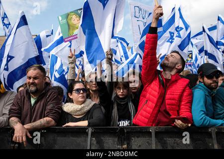 Jerusalem, Israel. 13. Februar 2023. Demonstranten mit israelischer Flagge bewegen sich während der Demonstration. Mehr als hundert Menschen protestierten, als der Knesset Law Committee die erste Genehmigungsphase der israelischen Rechtsüberholung durchlief. Kredit: SOPA Images Limited/Alamy Live News Stockfoto