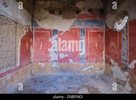 Ein Zimmer mit roten Fresken im Haus des Octavius Quartio. Im Archäologischen Park von Pompeji in der Nähe von Neapel, Italien. Stockfoto