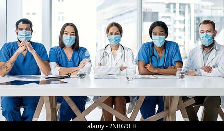 Verbesserung ihrer klinischen Leistung als engagiertes Team. Porträt einer Gruppe von Arztpraxen, die in einem Krankenhausvorstandssaal eine Tagung abhalten. Stockfoto