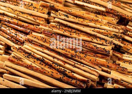 Brezelbrotstangen mit Sesamsamen. Leckere Brezeln in großen Mengen. Schließen Stockfoto