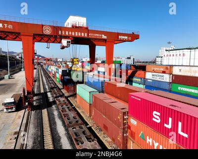 LIANYUNGANG, CHINA - 14. FEBRUAR 2023 - große Maschinen beladen Container in der Logistik-Kooperationsbasis China-Kasachstan (Lianyungang) in Lianyung Stockfoto