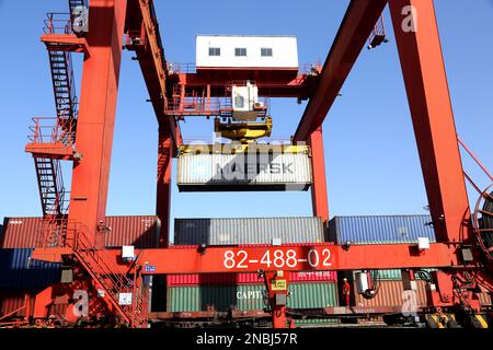 LIANYUNGANG, CHINA - 14. FEBRUAR 2023 - große Maschinen beladen Container in der Logistik-Kooperationsbasis China-Kasachstan (Lianyungang) in Lianyung Stockfoto