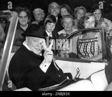 Sir Winston Churchill, former British prime minister, flashes famous “V” sign as he tours constituency of Woodford, England on Oct. 8, 1959. Sir Winston, now nearing 85, rode in an open car in a final bid for a seat in the House of Commons. (AP Photo/Dennis Lee Royle)