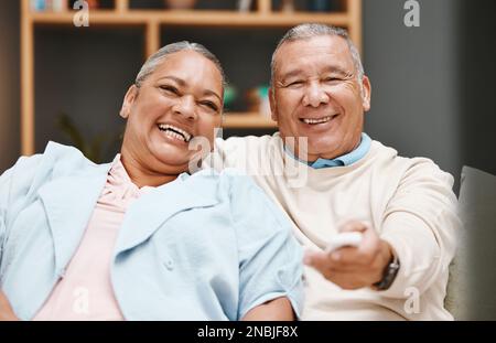 Liebe, Porträt und Seniorenpaar, die fernsehen, Spaß haben und beim Comic im Wohnzimmer lachen. Valentinstag, Romantik und ältere Rentner und Stockfoto