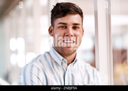 Jeder Herausforderung souverän begegnen. Gekürztes Porträt eines gutaussehenden jungen Designers, der in seinem Büro steht. Stockfoto