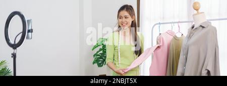 Mode Kleidung Online-Konzept, weibliche Verkäufer präsentiert Detail der neuen Kollektion auf Live-Streaming. Stockfoto