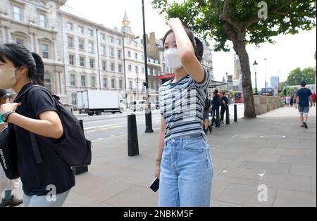 London, England, Großbritannien. Junge japanische Frau trägt eine Gesichtsmaske in Whitehall, Westminster, Juli 2022 Stockfoto