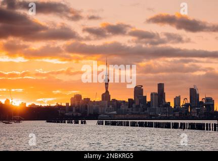 Blick auf den Sonnenuntergang über das Stadtbild von Aucklands Central Business District und den ikonischen Sky Tower, der die Skyline mit seinem beleuchteten Turm dominiert. Stockfoto