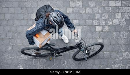 Lieferung, Verpacken und Mann mit Fahrrad und Kiste auf der Straße für Kundenbestellung in der Stadt. Transport, Kurier und männlicher Fahrradfahrer, vorrätig bei Stockfoto