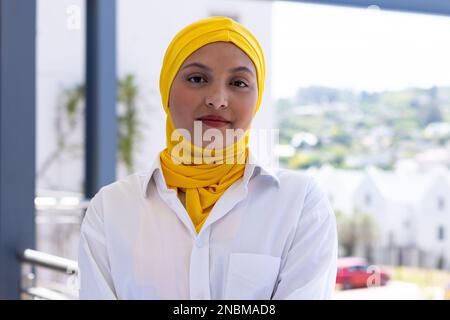 Porträt einer glücklichen birassischen Geschäftsfrau mit Hijab in einem modernen Büro. Globales Geschäfts-, Finanz- und Bürokonzept. Stockfoto