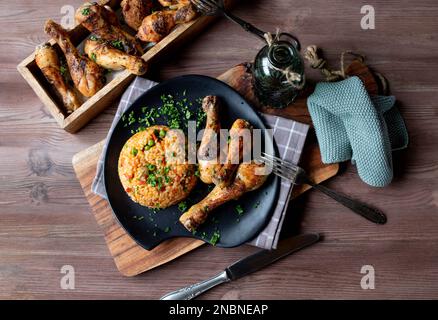 Gebackenes Hähnchen mit Gemüse-Reis auf einem Teller. Gekocht mit braunem Reis Stockfoto