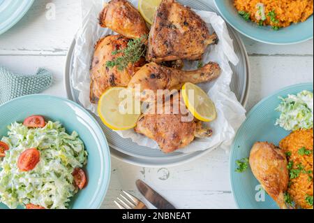 Gebackenes Hähnchen mit Tomatenreis und Salat zum Abendessen oder Mittagessen Stockfoto