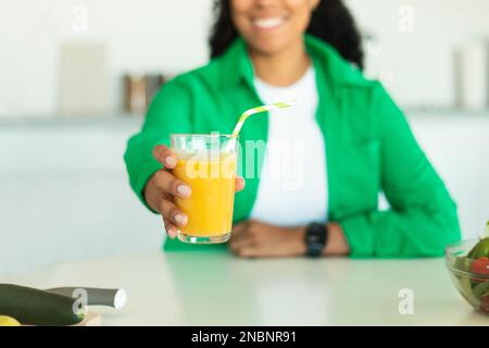 Unbekannte Schwarze, die Ein Glas Saft in der Küche anbietet Stockfoto