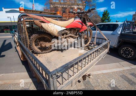 Ein Landmaschinen- oder Landwirtschaftsmotorrad, das auf der Rückseite eines 4WD ute montiert ist und bei 90 Grad zum Bordstein in Parkes, New South Wales, Australien, geparkt ist Stockfoto