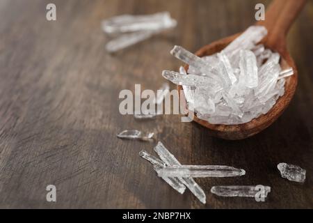 Menthol-Kristalle auf Holzhintergrund, Nahaufnahme. Platz für Text Stockfoto