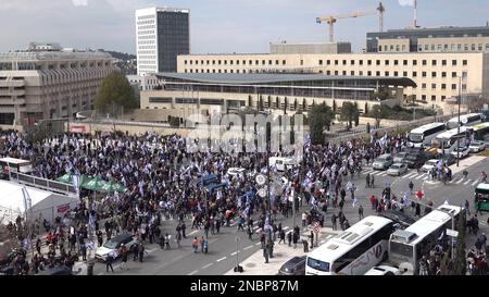 JERUSALEM, ISRAEL - FEBRUAR 13: Demonstranten halten israelische Flaggen, während sie auf dem Weg zu einer Massendemonstration gegen Israels neuen Plan des Justizsystems der Regierung sind, der darauf abzielt, den Obersten Gerichtshof des Landes außerhalb des israelischen parlaments (Knesset) am 13. Februar 2023 in Jerusalem, Israel, zu schwächen. Kredit: Eddie Gerald/Alamy Live News Stockfoto