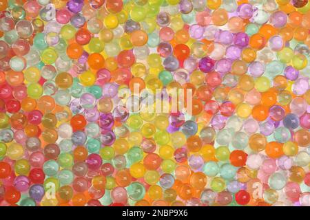 Nahaufnahme von Vasenfüllungen in verschiedenen Farben als Hintergrund. Wasserperlen Stockfoto