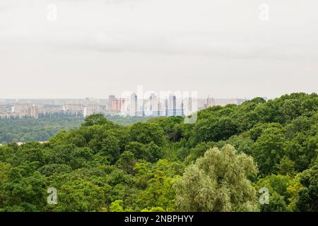 Kiew, Ukraine. Juli 19. 2014. Stadtbild von Kiew, Blick auf das linke Ufer und den Fluss Dnieper. Moderne Stadt in der Ferne, abends. Stockfoto