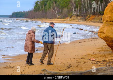 An einem Tag im Februar ging ein älteres Paar am Meer entlang. Einen Tag vor dem Valentinstag, Liebes. Wahre Liebe. Ostseeküste, Veczemju Klippe. Stockfoto