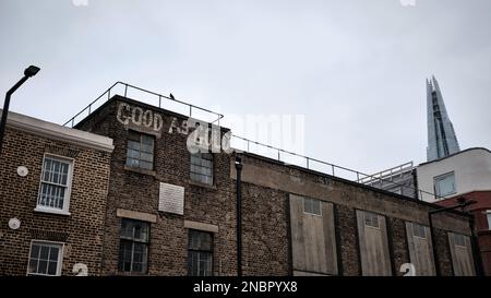 Graffiti "Good as Gold" auf einem Waterloo-Gebäude, im Süden Londons mit "The Shard" im Hintergrund und einer Taube, die auf dem Geländer sitzt Stockfoto