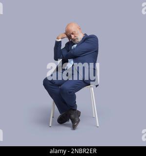 Senior Business Businessman sitzt auf einem Stuhl und schläft Stockfoto