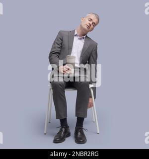 Fauler, müde Geschäftsmann sitzt auf einem Stuhl und schläft ein Stockfoto