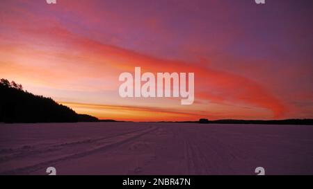 Morgenglühen auf dem Suvasvesi-See. Vehmersalmi, Kuopio, Finnland, 2023-02-14 07:43 +02. Temp. -5 °C, Wind NW 2 m/s. Stockfoto