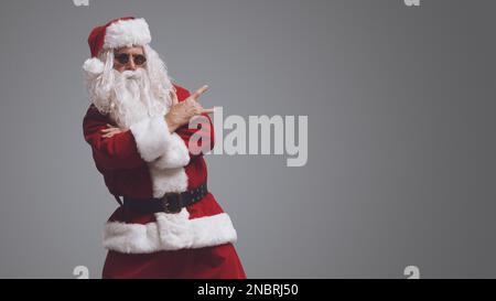 Cool rockender Weihnachtsmann mit Sonnenbrille, Weihnachts- und Urlaubskonzept Stockfoto