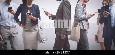 Eine Menge abgelenkter Menschen, die auf der Straße der Stadt laufen und Smartphones benutzen, Internet-Suchtkonzept Stockfoto
