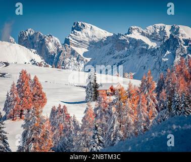 Zwei hölzerne Chalets im Bergtal. Fantastischer Blick am Morgen auf das Dorf Alpe di Siusi mit dem Furchetta-Gipfel im Hintergrund. Atemberaubende Winterszene von Dolom Stockfoto