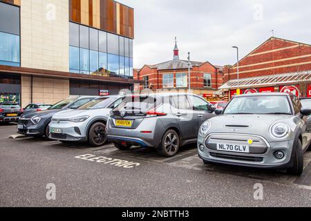 Elektrische WASSERWAAGE 2020 Grey MINI COOPER S 1, 2019 Grey NISSAN LEAF Plus Launch Edition, 2022 VW Volkswagen ID4 LIFE SEL TSI 4MOTION DSG, Ladestation für Elektroautos, Flat Iron Shoppers Car Park, Chorley UK Stockfoto