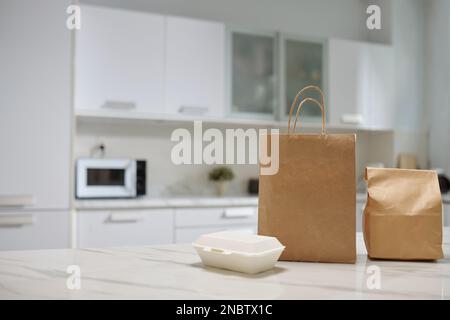 Pakete mit Speisen, die vom lokalen Café an der Küchentheke geliefert werden Stockfoto