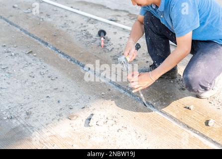 Bauarbeiter bei der Arbeit mit Hammer und Meißel graben Beton auf einer Baustelle Stockfoto