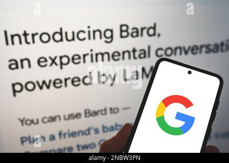 Google führt Bard AI ein. Google-Logo auf dem Telefon in der Hand mit Veröffentlichungsinformationen zum Hintergrund. Google Bard AI im Vergleich zu OpenAI ChatGPT. Warschau, Polen - 8. Februar 2023. Stockfoto