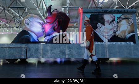 Köln, Deutschland. 14. Februar 2023. Ein Themenwagen, auf dem der russische Präsident Wladimir Putin den Teufel küsst, wird bei der Bestendigungszeremonie für die Parade am Kölner Rosenmontag in Koelnmesse enthüllt. Kredit: Rolf Vennenbernd/dpa/Alamy Live News Stockfoto